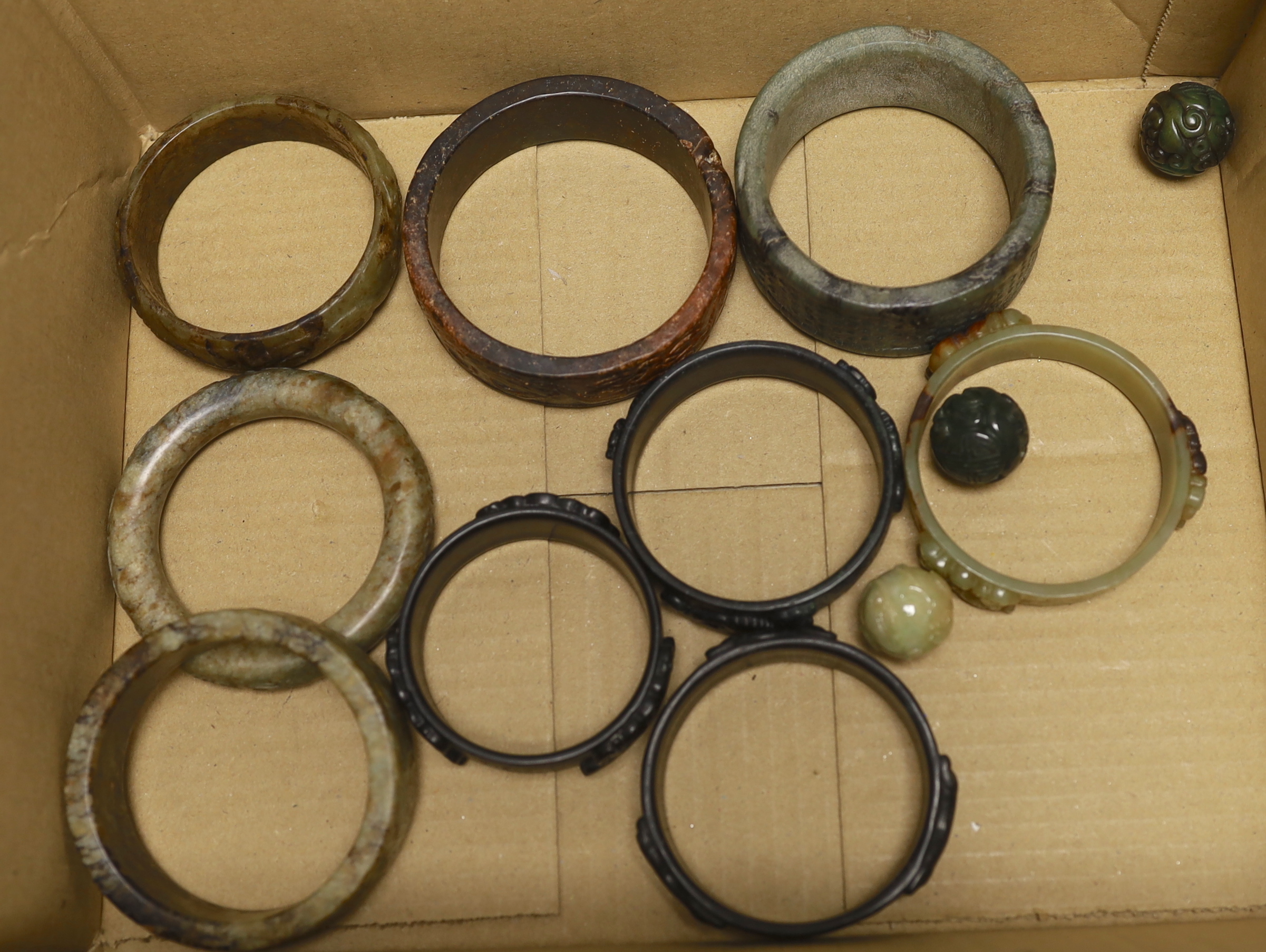 Nine assorted Chinese jade and hardstone bangles and three spheres, largest bangle 8.5cm diameter